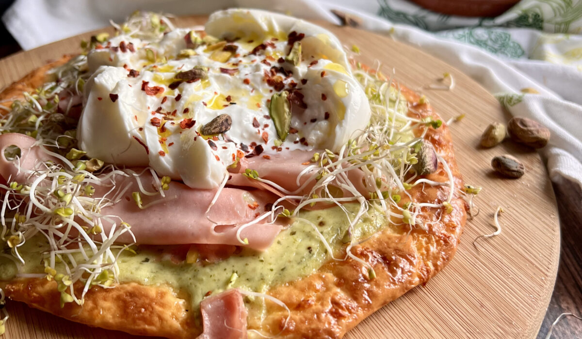 Keto pizza z burratą, włoską mortadelą i pesto pistacjowym.