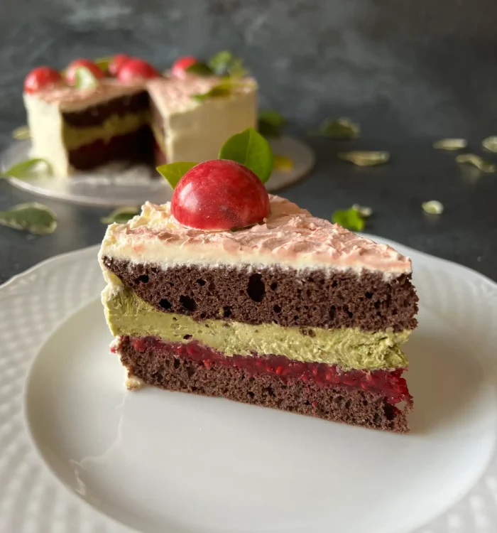 Tort kakaowy z kremem pistacjowym i malinami